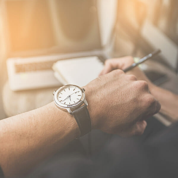 Braccio di uomo con orologio che legge l&#039;ora