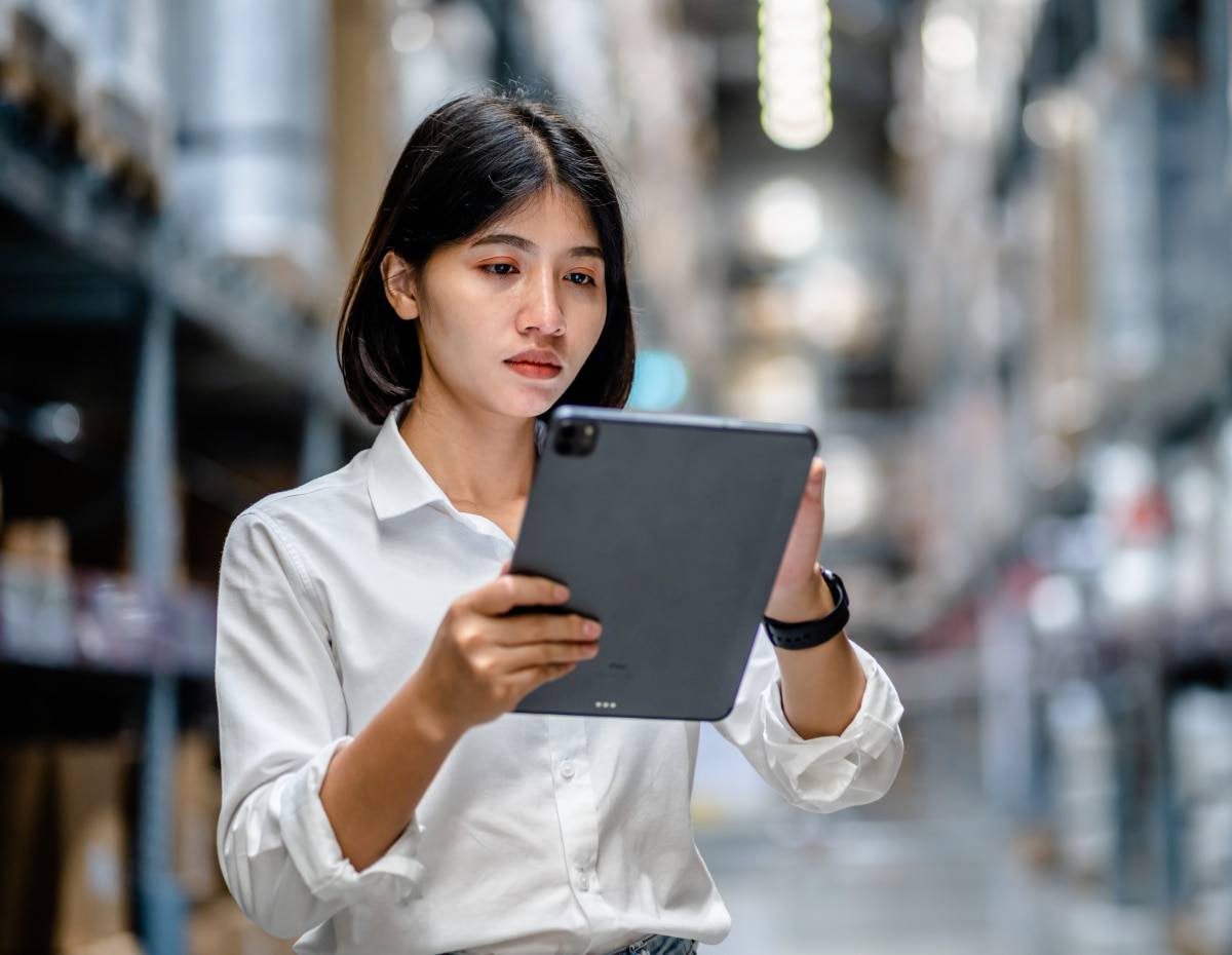 manufacturing worker on a tablet forecasting data