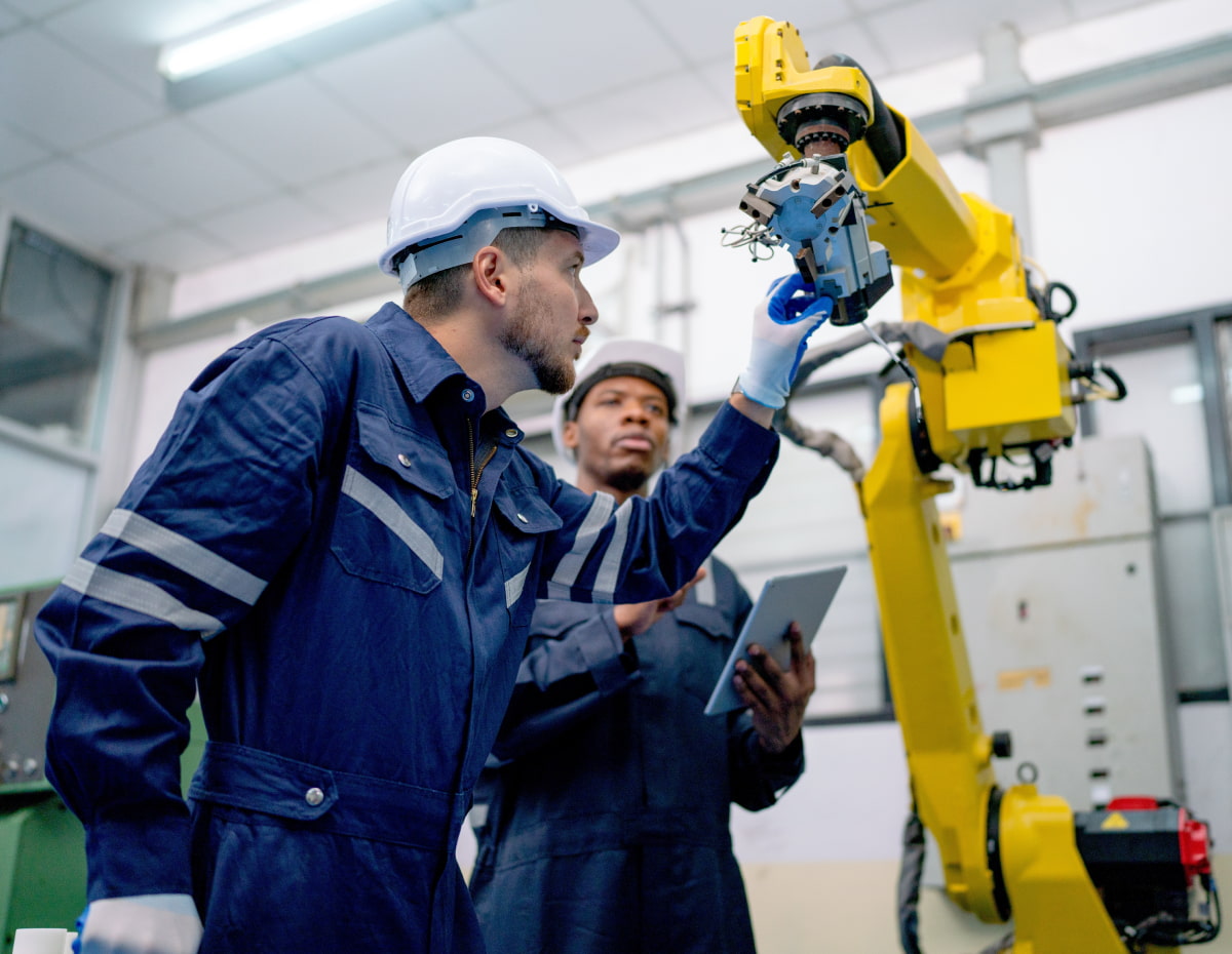 two manufacturing workers conducting maintenance on a machine